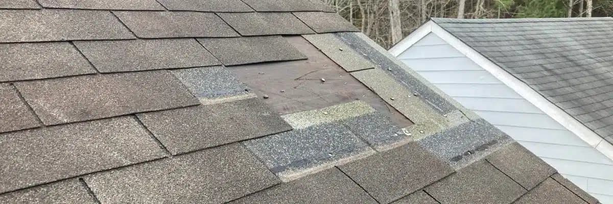 Damaged roof shingles and a roof patch that need professional inspection